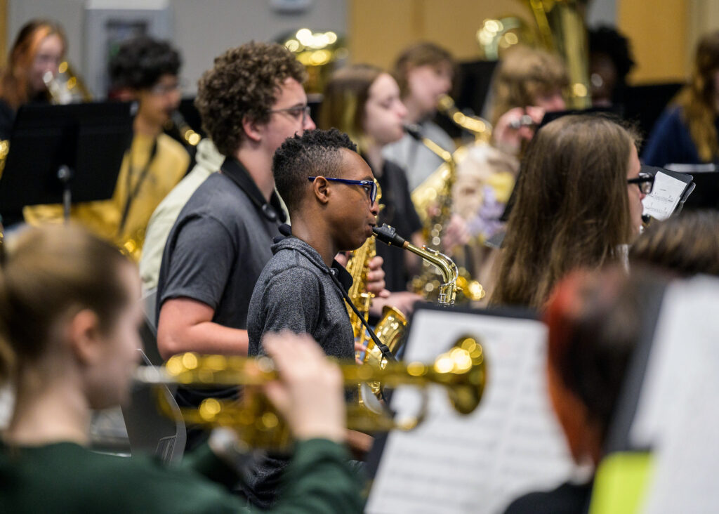 wind ensemble members play their instruments during a rehearsal